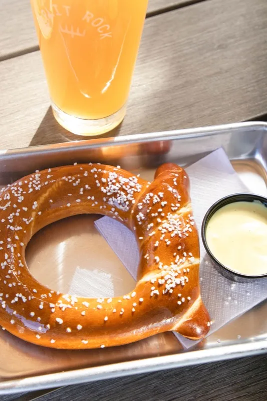 Warm soft pretzel served with beer cheese