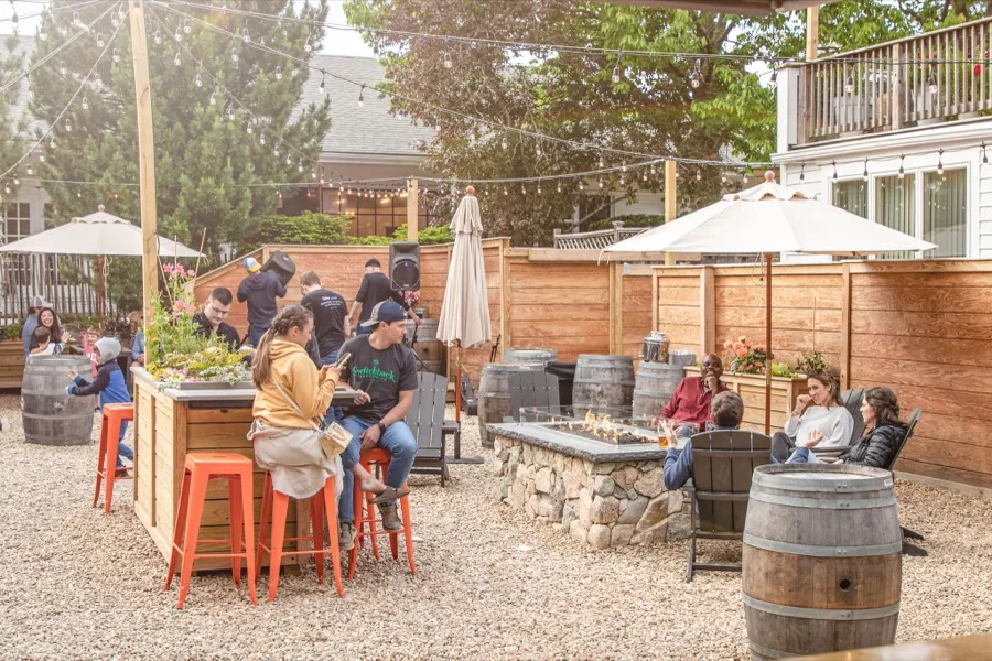 Split Rock Cohasset outdoor beer garden with string lights and umbrellas